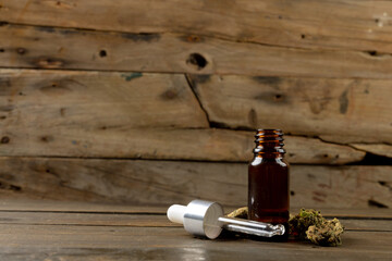 Obraz na płótnie Canvas Image of bottle of cbd oil and dried marihuana leaves on wooden surface
