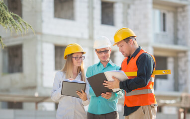 an engineer, an accountant, an estimator and a foreman worker confer about drawing up an estimate...