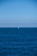 Obraz premium Luarca, Asturias, Spain; June 16, 2022; A beautiful sea view on the coast of Luarca. Lone boat sailing in the sea.