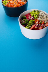 Close up of two hawaiian poke bowls with copy space on blue background