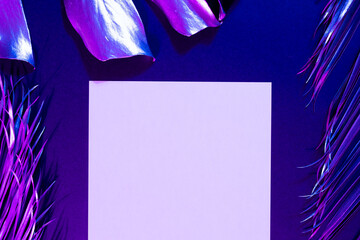 Image of vibrant neon lit purple leaves over purple background and paper with copy space