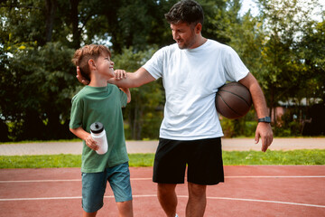 Father and son connect through sports activities, play basketball and enjoy a sunny day