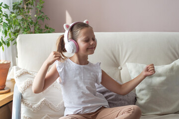 A 10-year-old girl listens to music in headphones