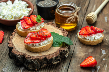 Bruschetta with strawberry and cream cheese ricotta on a wooden background. banner menu recipe place for text
