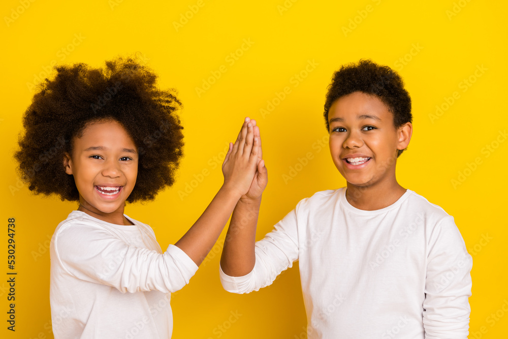 Sticker photo of friendly excited schoolboy schoolgirl wear white shirts giving high five isolated yellow co