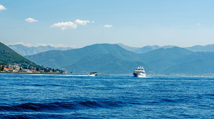 Fototapeta na wymiar Boat in Adriatic sea in Montenegro in sunny day. Touristic sailing excursions with beautiful mountains nature view