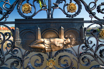 A detail view of iron forged grid with Saint John of Nepomuk relief on Charles Bridge in Prague,...