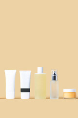 Simple 5 step cosmetic skin care routine.Cleanser,  gommage, toner, serum and cream  on  beige background. Beauty concept