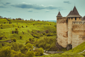Old brick fortress in Khotyn. Ancient castle, green meadow hills. Majestic fortification on the...