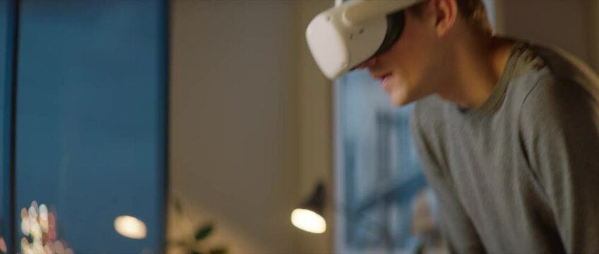 Portait of Caucasian male architect or student using a virtual reality VR headset to work on a house project late at night, preparing for presentation with a client