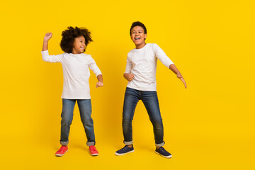 Full size photo of excited funky pupils enjoy dancing disco isolated on yellow color background