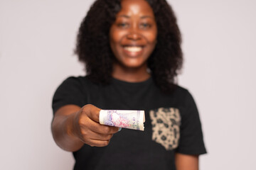 african lady stretches money forward towards viewer