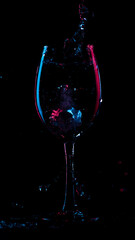 Multicolored silhouette of a glass on a dark background