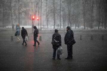 Snow outside. Snowfall in city. People in wet weather.