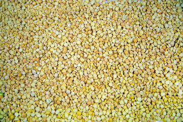 Background of crushed peas (Latin Písum) with beautiful yellow grains. Cereals legumes useful products agriculture.