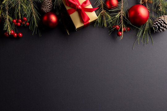 Image of christmas decorations with baubles and copy space on black background
