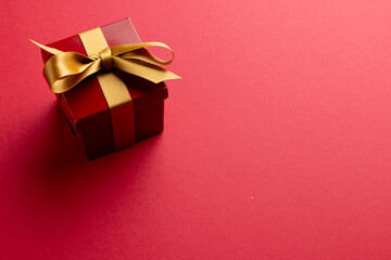 Image of red christmas gift decoration and copy space on red background