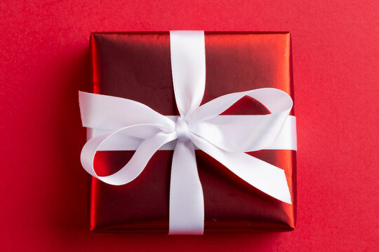 Image of close up of red christmas gift decoration and copy space on red background