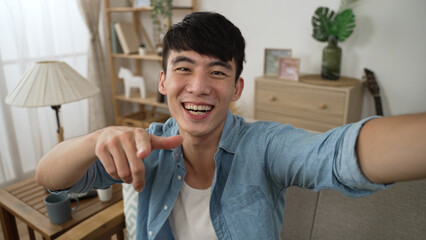 mobile cam view of a happy asian man is talking and explaining with hand gestures while making a...