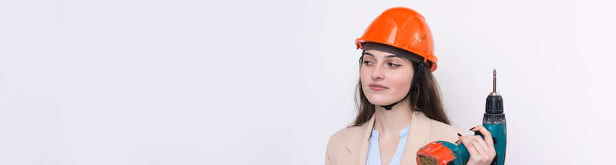 Girl engineer in an orange construction helmet with a screwdriver and a hammer on a white background.