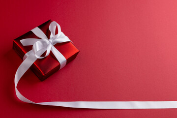 Image of christmas decoration with red gift and copy space on red background