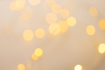 Image of out of focus christmas fairy lights and copy space on cream background