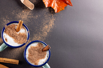 Image of two christmas mugs of milk with cinnamon with copy space on grey - Powered by Adobe