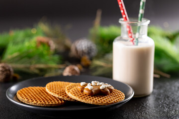 Image of glass of milk and biscuits with christmas decorations and copy space on grey
