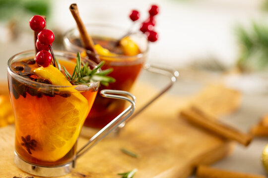 Image of two cups of tea with spices and lemon and christmas decorations with copy space