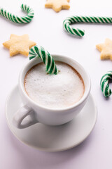 Green christmas canes, christmas cookies and cup of coffee over white background