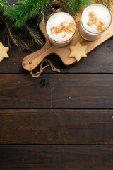 Image of two glasses of christmas milk with christmas decoration and copy space on wood