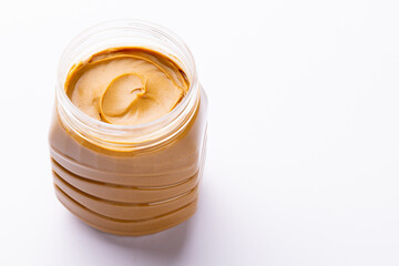 Image of jar with peanut butter on white surface