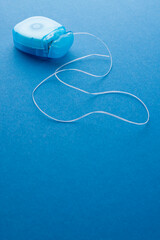 Vertical image of dental string on blue surface