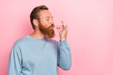 Photo of handsome cheerful man with ginger hairstyle dressed blue long sleeve tasting delicious food isolated on pink color background