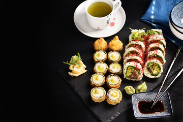 Background with Japanese sushi set and green tea on black board © teressa