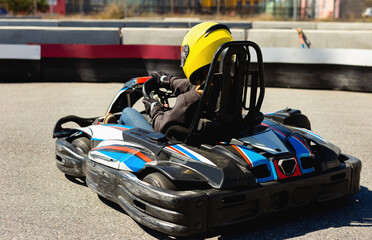 Glad cheerful smiling woman driving sport car for karting in a circuit lap outdoor in sport club