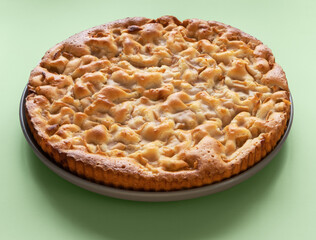 homemade apple pie on a green background in a gray plate
