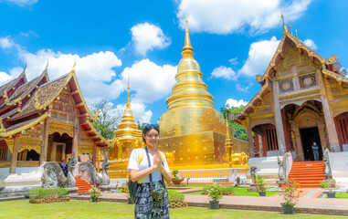 A young woman praying at Wat Phra Singh, a famous tourist attraction and attraction in Chiang Mai, Thailand.