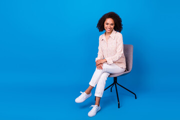 Photo of pretty adorable lady wear pink shirt sitting office chair empty space isolated blue color...