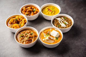 Obraz na płótnie Canvas Group of Indian vegetarian dishes, hot and spicy Punjabi cuisine meal assortment in bowls