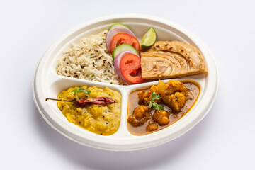 Indian mini meal parcel platter or combo thali with Gobi Masala, roti, dal tarka, jeera rice, salad