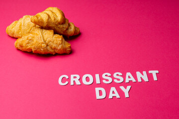 Image of croissants and croissant day on pink background