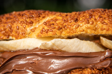 A sandwich with chocolate spread and banana. Bagel, simit, bread with bananas and chocolate cream on. tasty sweet breakfast or lunch sandwich with hazelnut chocolate spread and fresh banana slices