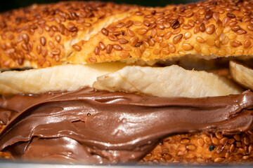A sandwich with chocolate spread and banana. Bagel, simit, bread with bananas and chocolate cream on. tasty sweet breakfast or lunch sandwich with hazelnut chocolate spread and fresh banana slices