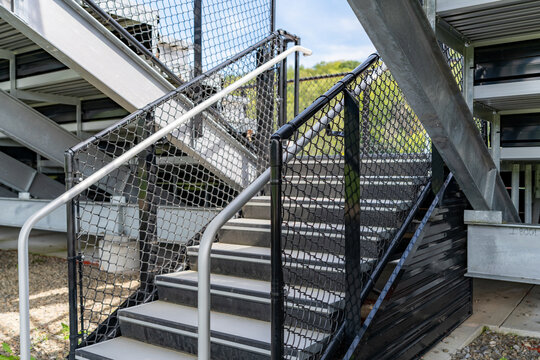 Example of an exit, entrance, vomitorium at empty set of metal stadium bleacher - grandstands with steps and railing. Nondescript location with no people in image. Not a ticketed event.