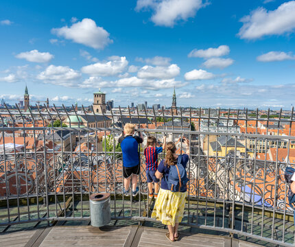 Family enjoying aerial view of Copenhagen, Denmark from Round Tower (Rundetaarn), a 17th-century tower built as an astronomical observatory in the center of town.