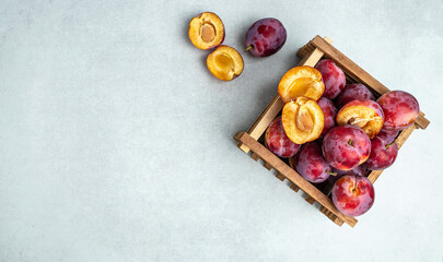 Plums. fresh ripe plums in a basket. background of beautiful home plums on a light background. Long banner format. top view