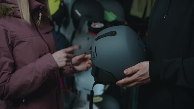 A consultant in the store helps you choose a helmet for winter sports