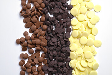 Close up of three types of couverture chocolate. Chocolate callets isolated on white.