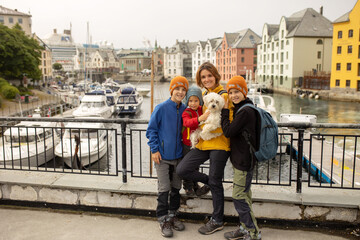 Family, kids, adults and dog, enjoying family vacation in Alesund, beautiful city in Norway - obrazy, fototapety, plakaty